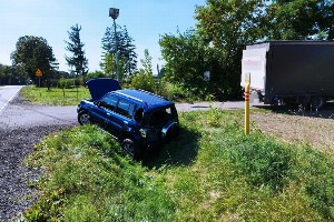 uszkodzony samochód SUV w rowie w dzień latem